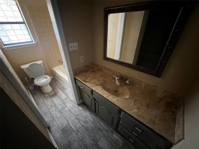 a view of a livingroom with an empty space wooden floor and a ceiling fan