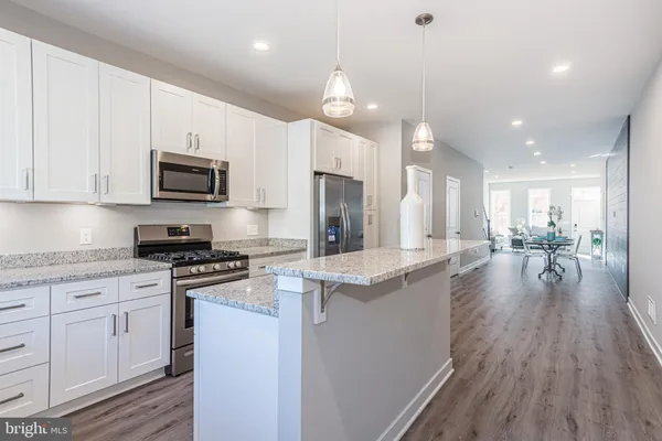 a kitchen with granite countertop cabinets stainless steel appliances a sink and a window