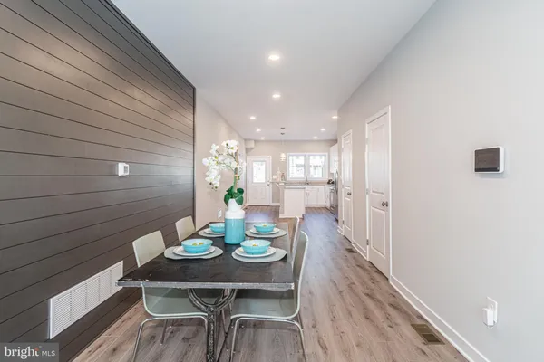 a kitchen with stainless steel appliances granite countertop wooden floors a stove a sink and a refrigerator