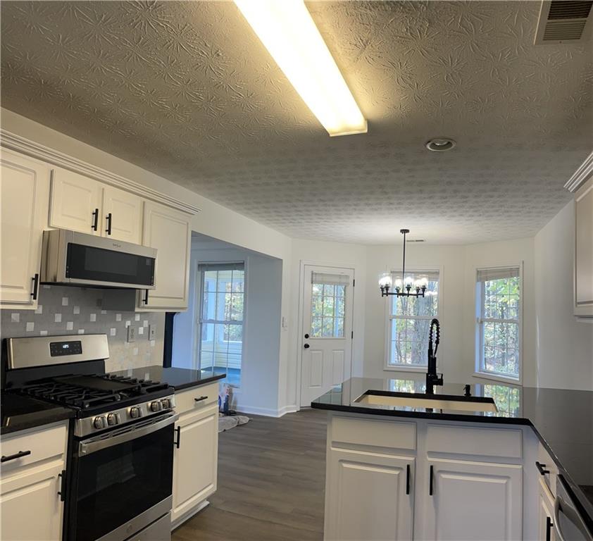 3920 Knotts Pass Road Southwest Snellville, GA 30039 - Photo 5 of 19 a kitchen with stainless steel appliances granite countertop a sink and stove