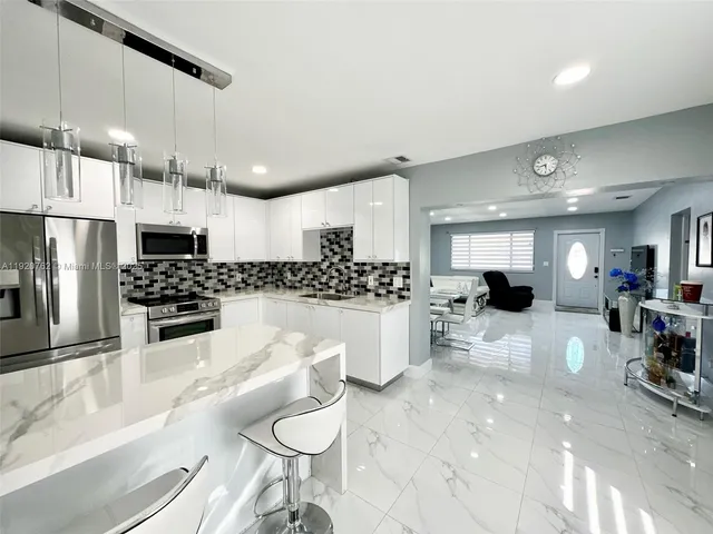 a kitchen with white cabinets and appliances