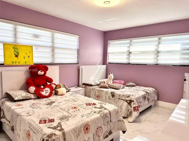 a bedroom with two beds and a large window