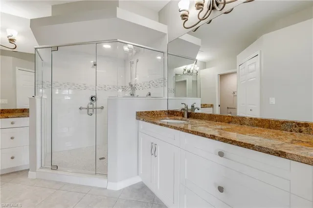 a bathroom with a granite countertop sink mirror and shower