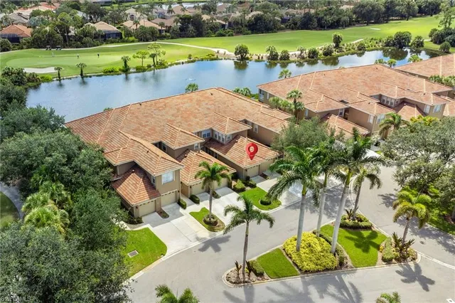 an aerial view of a house with a garden and lake view