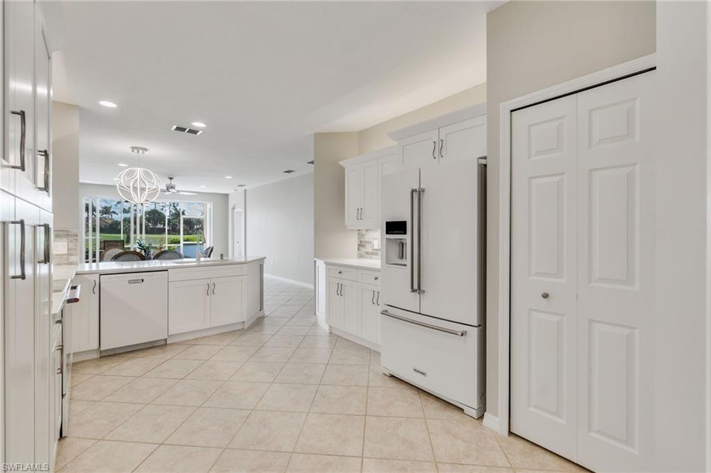 20031 Seagrove Street, Unit 1403 Estero, FL 33928 - Photo 7 of 28 a kitchen with white cabinets and white appliances