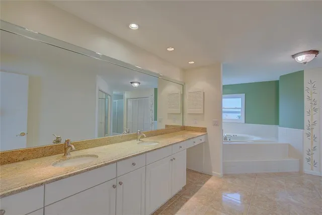 a bathroom with a granite countertop sink mirror and a bath tub