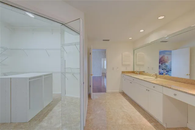 a large white kitchen with a sink and cabinets