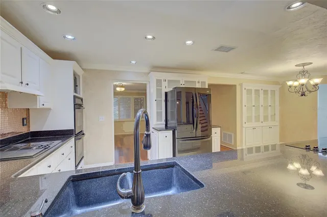 a view of a kitchen with refrigerator and windows
