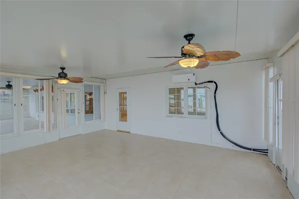 a view of a livingroom with a chandelier fan and a window