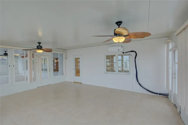 a view of a livingroom with a chandelier fan and a window