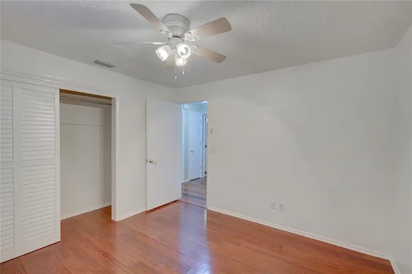 a view of an empty room with wooden floor