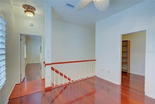 a view of a hallway with wooden floor and staircase