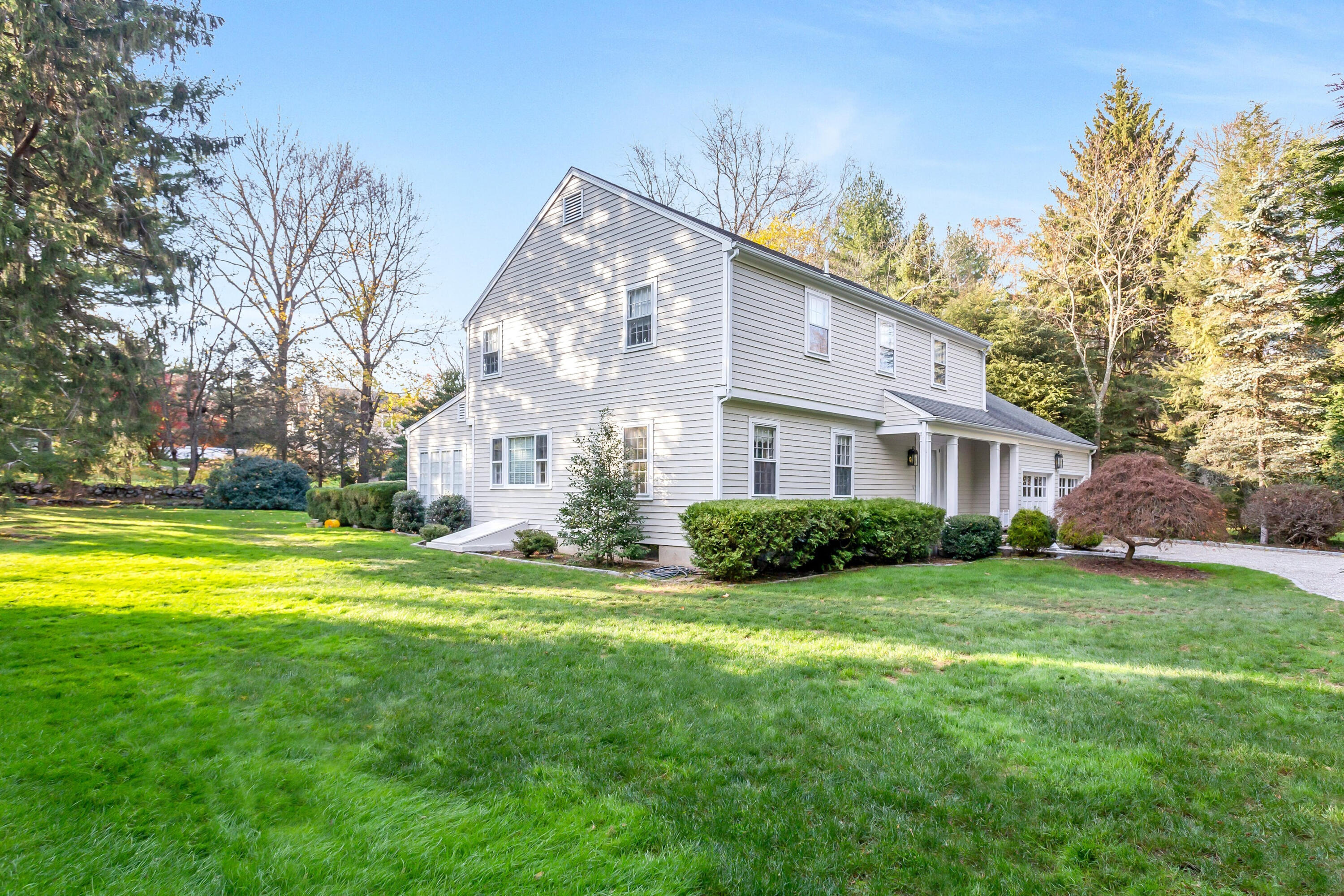 9 Peterick Lane Darien, CT 06820 - Photo 2 of 28 a view of a house with a big yard and large trees