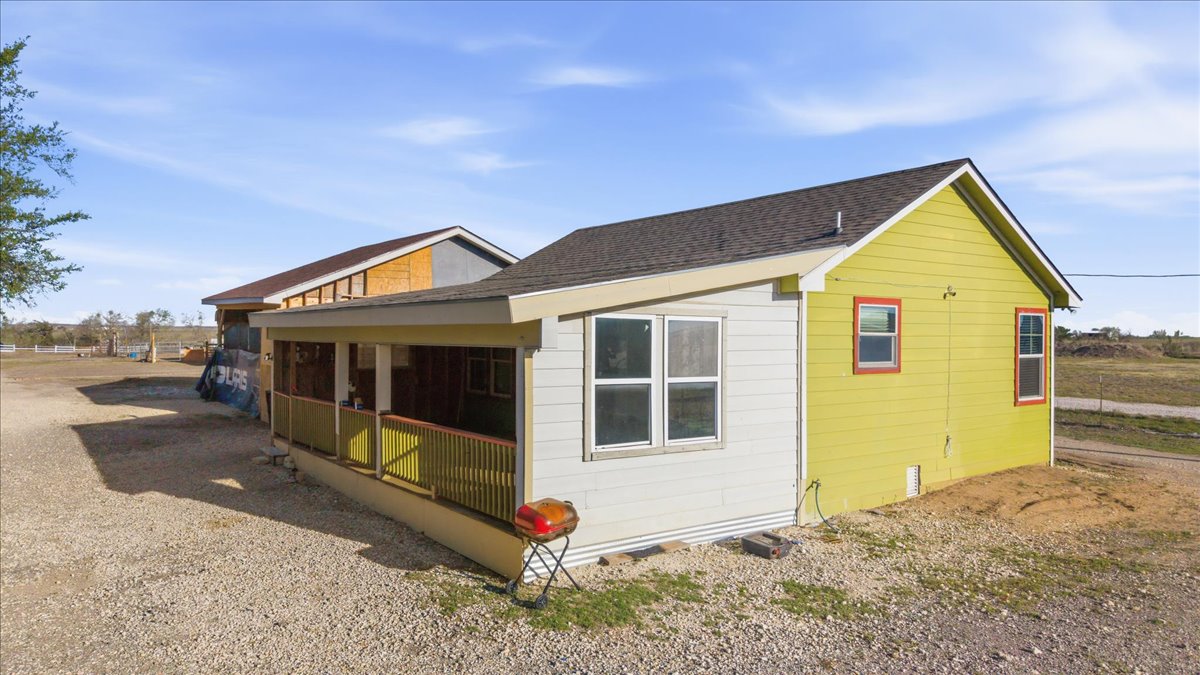 17309 Skog Road Elgin, TX 78621 - Photo 15 of 17 View of side of home featuring a sunroom and roof with shingles