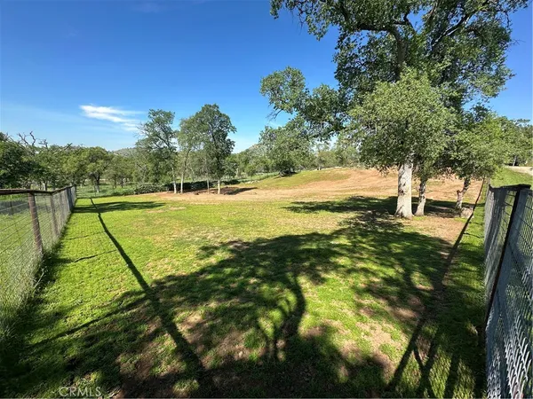 a view of a yard with wooden fence