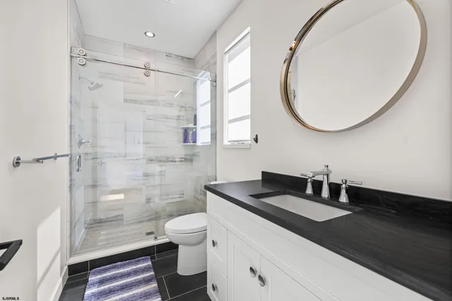 a bedroom with a bed and dresser with mirror