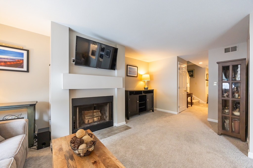 99 Stone Ridge Road, Unit 99 Franklin, MA 02038 - Photo 18 of 39 a living room with furniture and a fireplace
