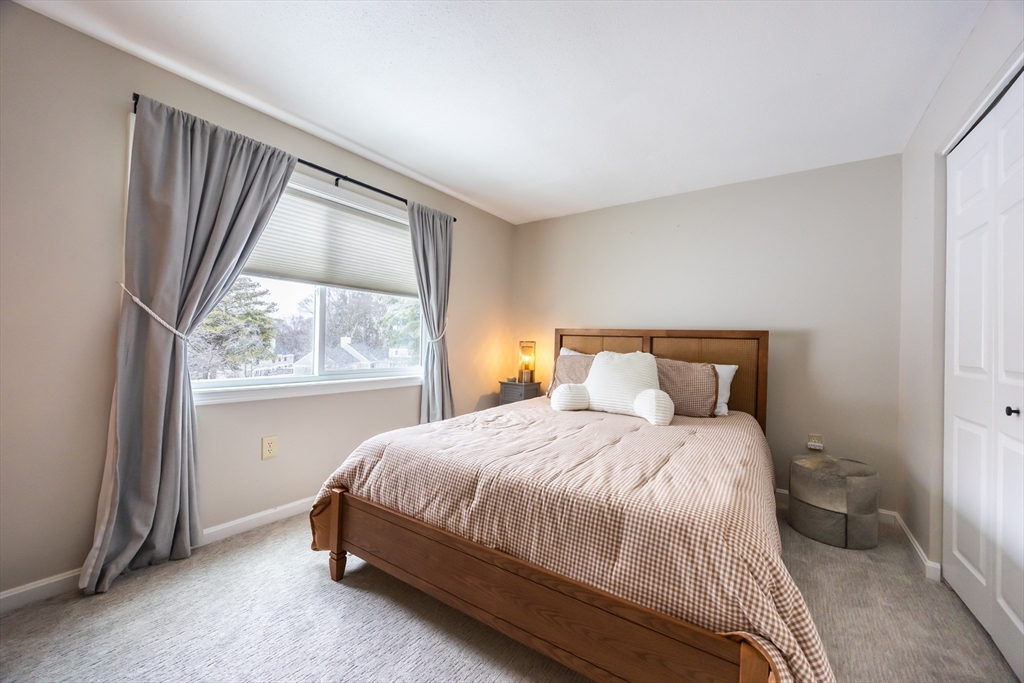 99 Stone Ridge Road, Unit 99 Franklin, MA 02038 - Photo 22 of 39 a bedroom with a bed and a large window