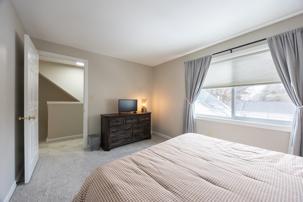 99 Stone Ridge Road, Unit 99 Franklin, MA 02038 - Photo 23 of 39 a bedroom with a bed window and a television