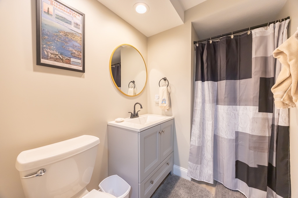 99 Stone Ridge Road, Unit 99 Franklin, MA 02038 - Photo 26 of 39 a bathroom with a toilet sink vanity tub and mirror