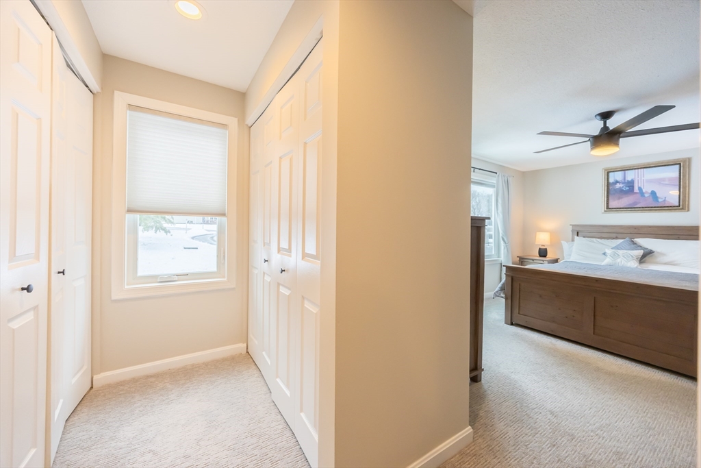 99 Stone Ridge Road, Unit 99 Franklin, MA 02038 - Photo 33 of 39 a view of a hallway to a bedroom with furniture and window