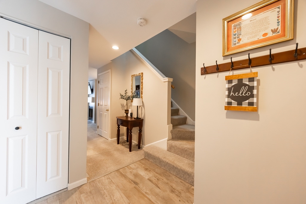99 Stone Ridge Road, Unit 99 Franklin, MA 02038 - Photo 4 of 39 a view of a hallway with wooden floor and staircase