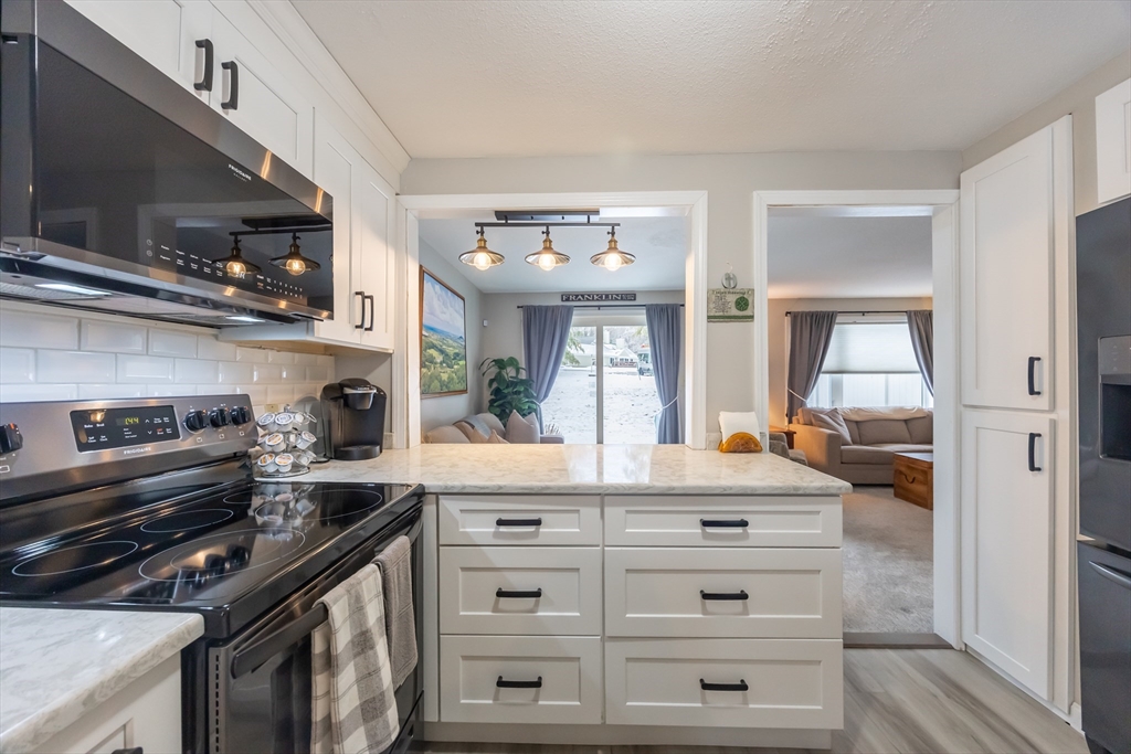 99 Stone Ridge Road, Unit 99 Franklin, MA 02038 - Photo 9 of 39 a kitchen with a stove and a microwave