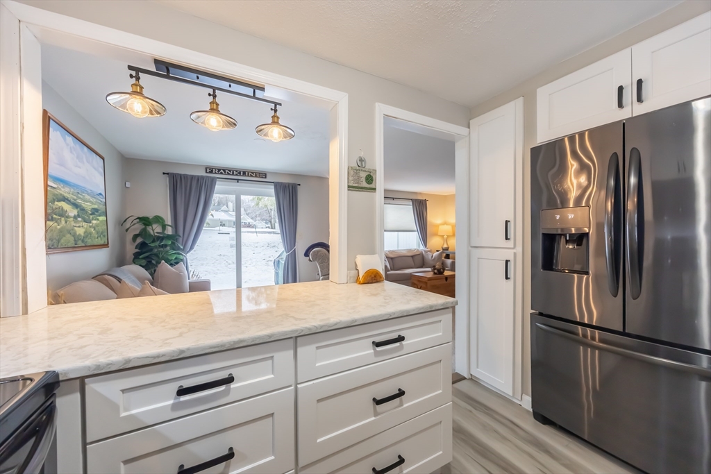 99 Stone Ridge Road, Unit 99 Franklin, MA 02038 - Photo 10 of 39 a kitchen with a refrigerator and countertop wooden floor