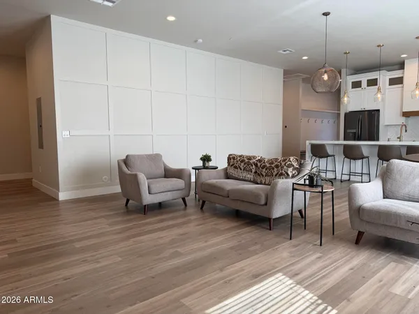 a view of an empty room with wooden floor and a bathroom