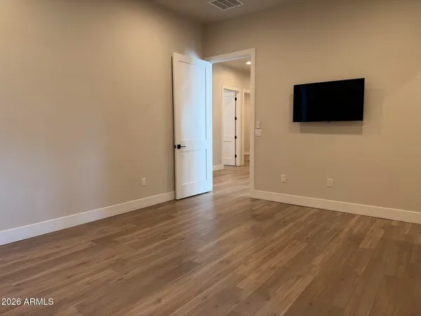 an empty room with wooden floor and windows