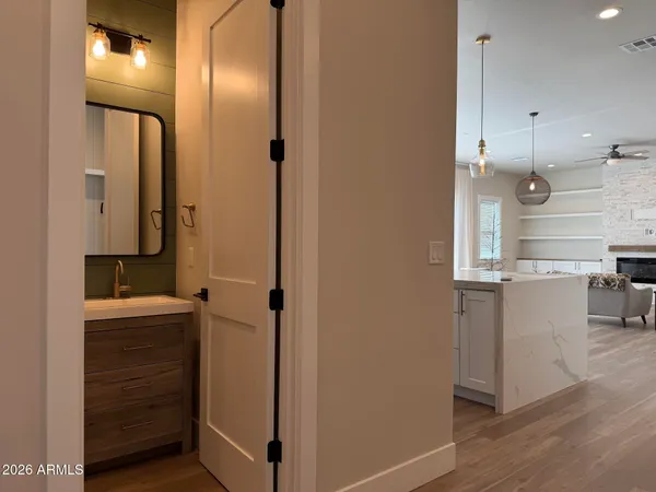 a kitchen with a sink dishwasher a refrigerator and a stove with wooden floor