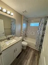 a bathroom with a granite countertop sink toilet and shower