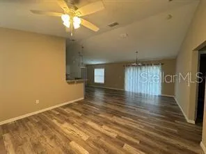 a view of an empty room with window and wooden floor
