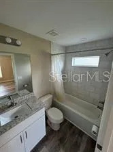 a bathroom with a granite countertop sink toilet and shower
