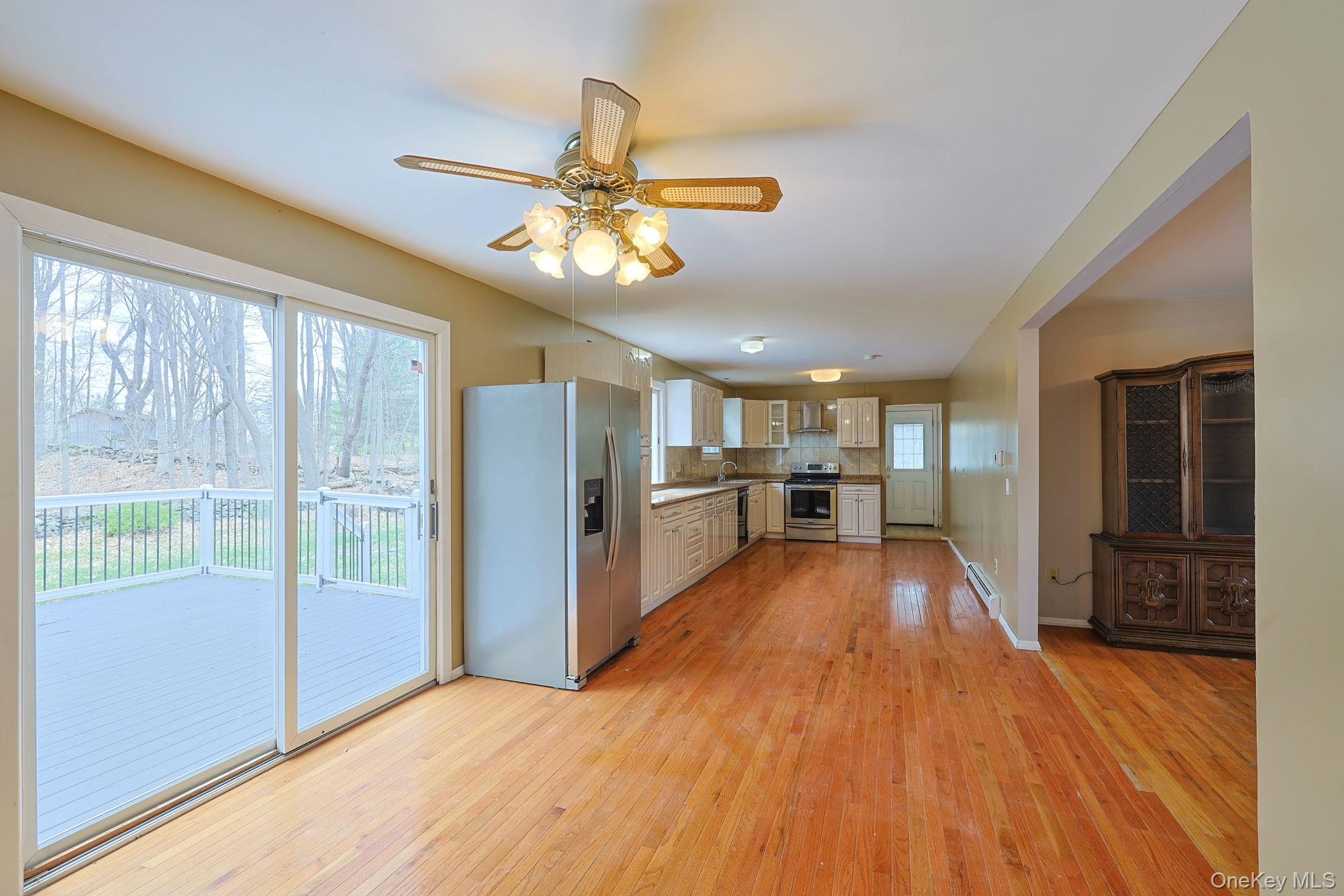 78 Pickerel Road Monroe, NY 10950 - Photo 9 of 41 a view of a kitchen with wooden floor a refrigerator a ceiling fan and wooden floor