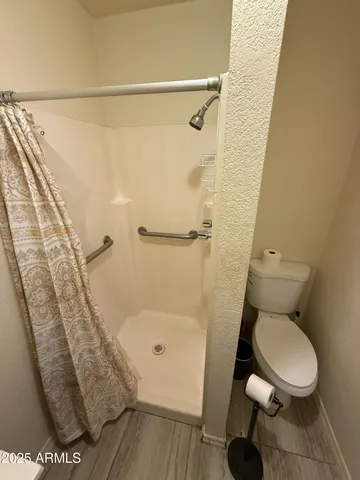 a bathroom with a toilet and a shower