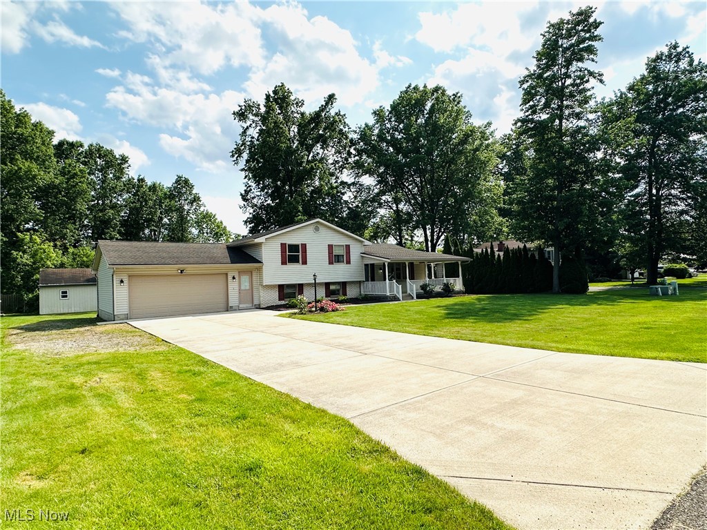 1684 Morris Street Mineral Ridge, OH 44440 - Photo 11 of 50 Split level home with a porch, a front yard, a garage, driveway, and brick siding