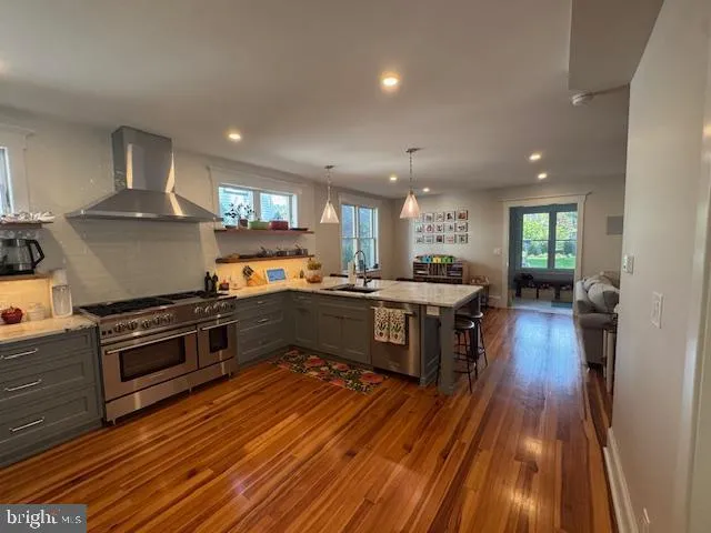 a kitchen with stainless steel appliances granite countertop a stove a sink and a refrigerator