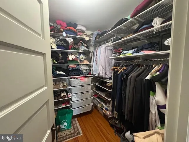 a view of walk in closet with clothes and shoes