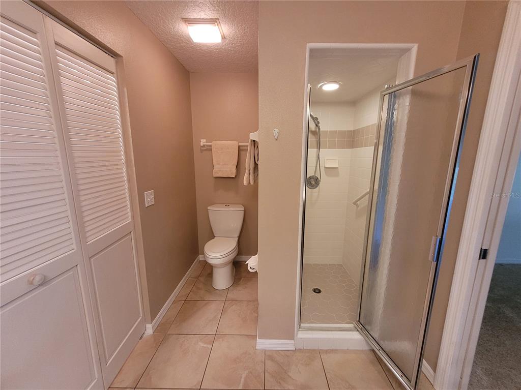 432 Baytree Boulevard Tavares, FL 32778 - Photo 23 of 65 a bathroom with a glass door shower a toilet and a sink