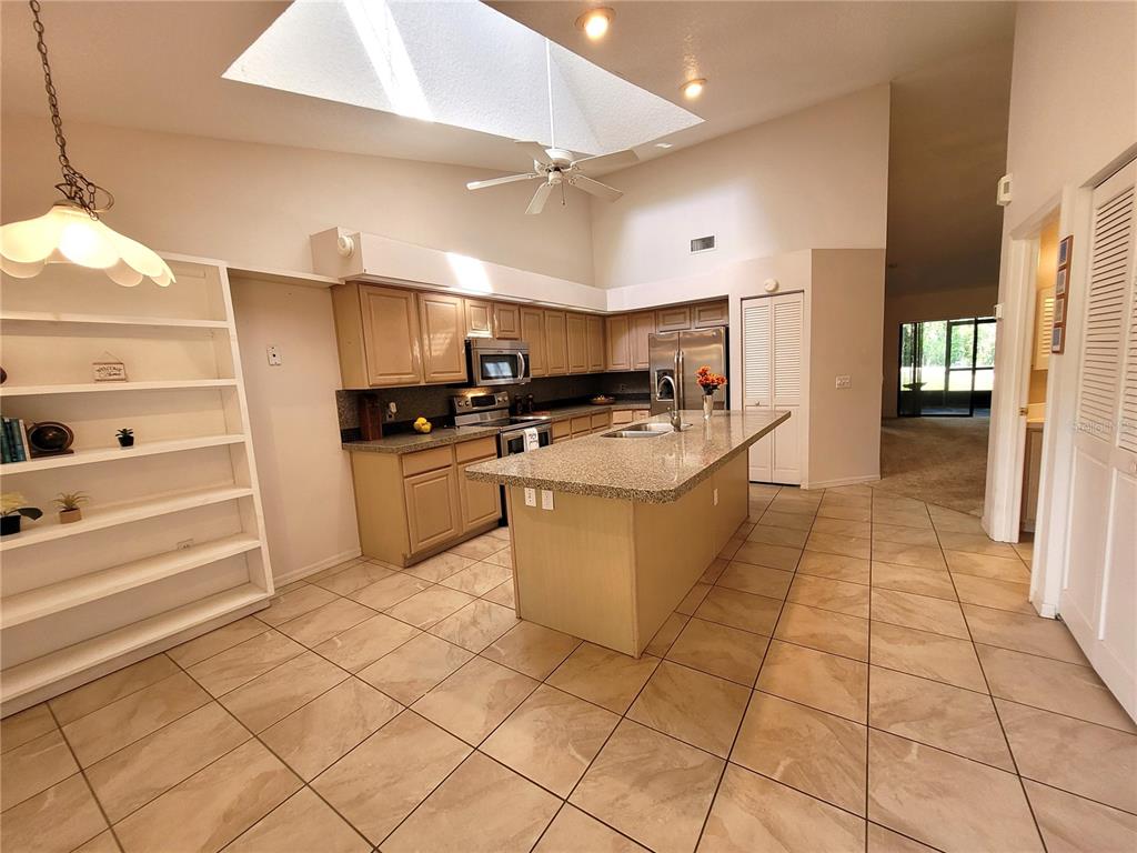 432 Baytree Boulevard Tavares, FL 32778 - Photo 6 of 65 a kitchen with stainless steel appliances granite countertop a stove a sink and a refrigerator