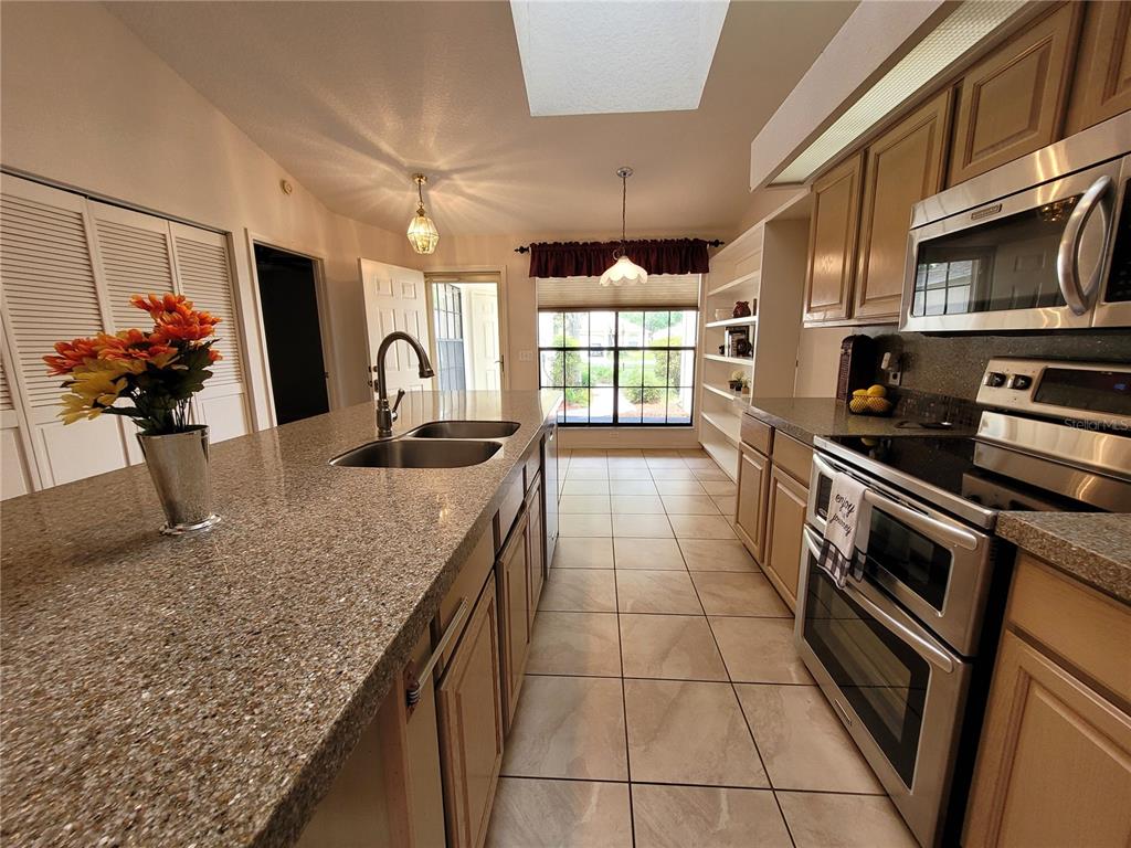 432 Baytree Boulevard Tavares, FL 32778 - Photo 10 of 65 a kitchen with stainless steel appliances granite countertop a sink stove and cabinets