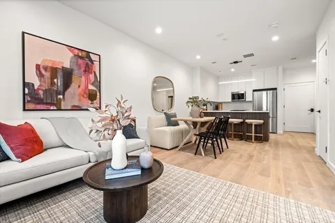 a living room with furniture and a view of kitchen