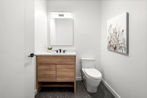 a bathroom with a toilet sink and mirror