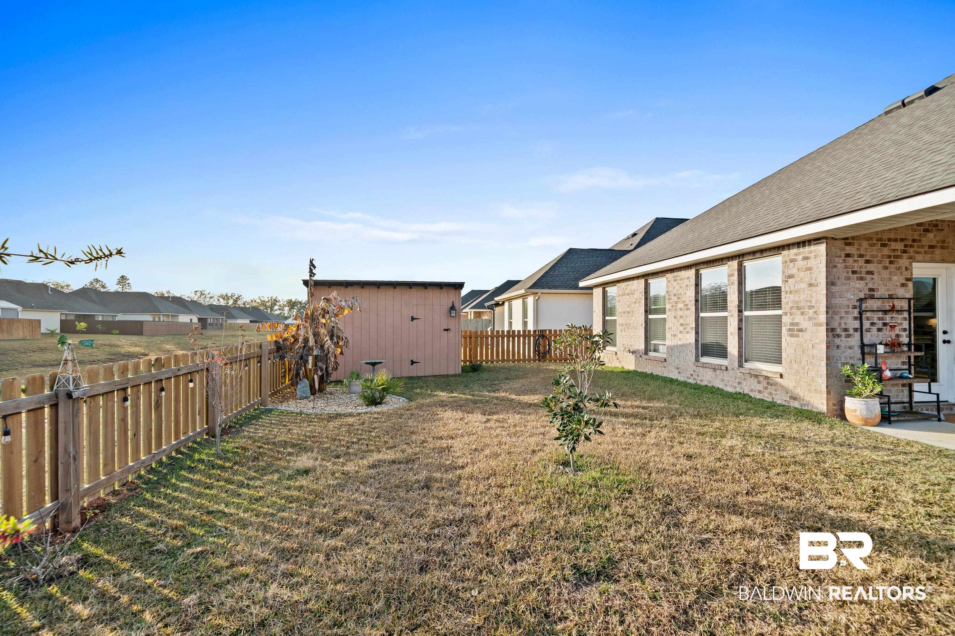 1390 Aldon Street Foley, AL 36535 - Photo 27 of 31 Fenced backyard featuring an outbuilding and a patio area