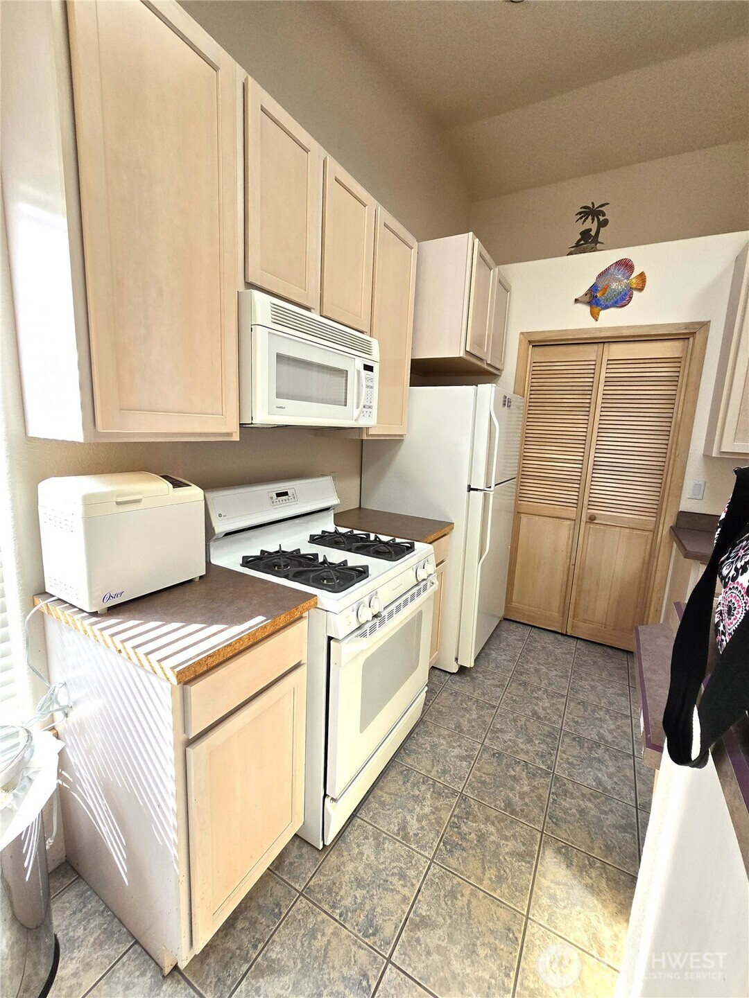 30100 H Street Ocean Park, WA 98640 - Photo 11 of 22 a kitchen with a stove top oven a sink a refrigerator and white cabinets