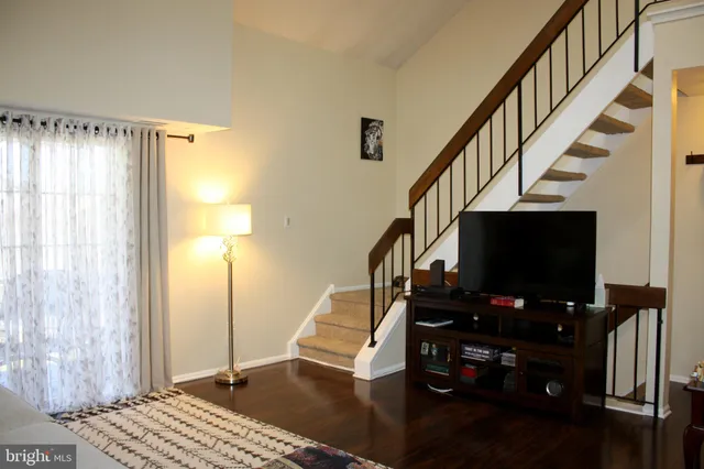 a living room with wooden floor and a flat screen tv
