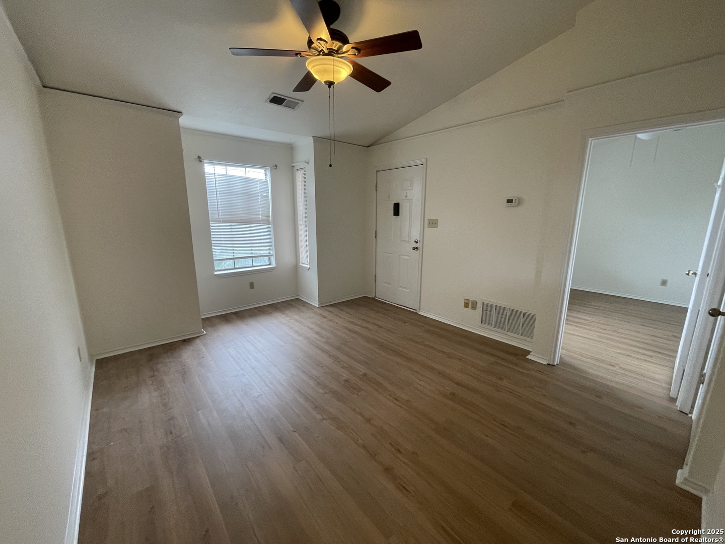 11610 Vance Jackson, Unit 982 San Antonio, TX 78230 - Photo 2 of 9 an empty room with wooden floor and windows