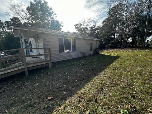 a view of house with yard and sitting area