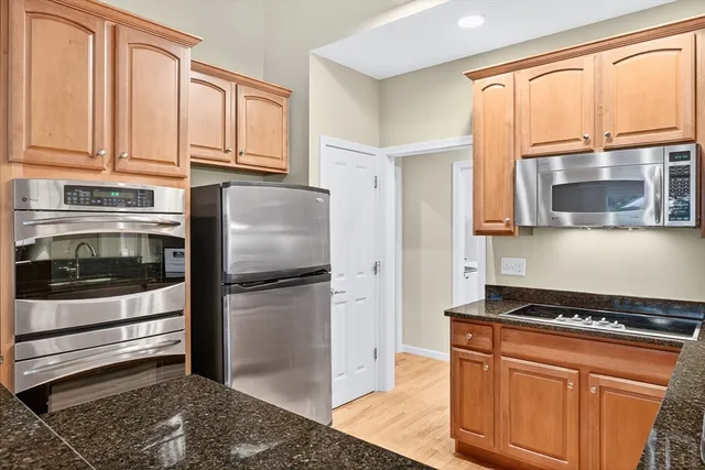 a kitchen with stainless steel appliances granite countertop a refrigerator stove and sink